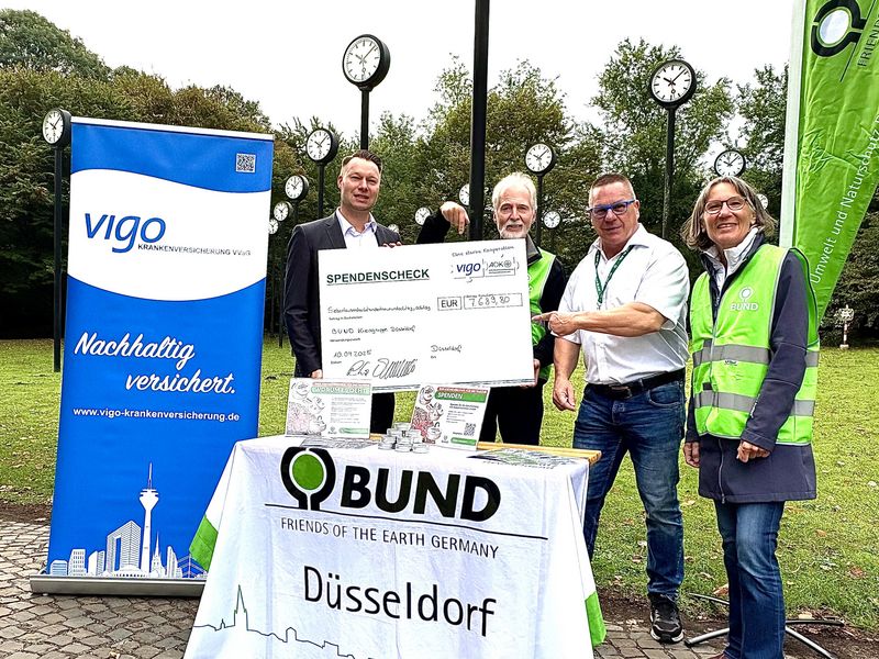 4 Personen am BUND Tisch mit Spendentafel