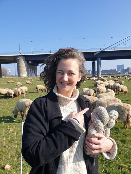 Frau mit Wollknäuel im Arm