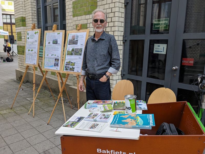 Mann mit Lastenrad vor Plakaten