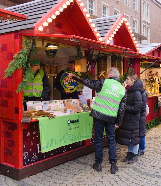 Personen am BUND Stand auf dem Weihnachtsmarkt