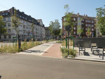 Straße mit Bepflanzung und Radstation